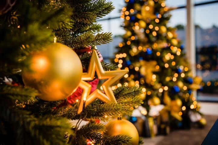 Sfeervol versierde kerstbomen met gouden ballen en sterren bij Bitter en Zoet in Veenhuizen