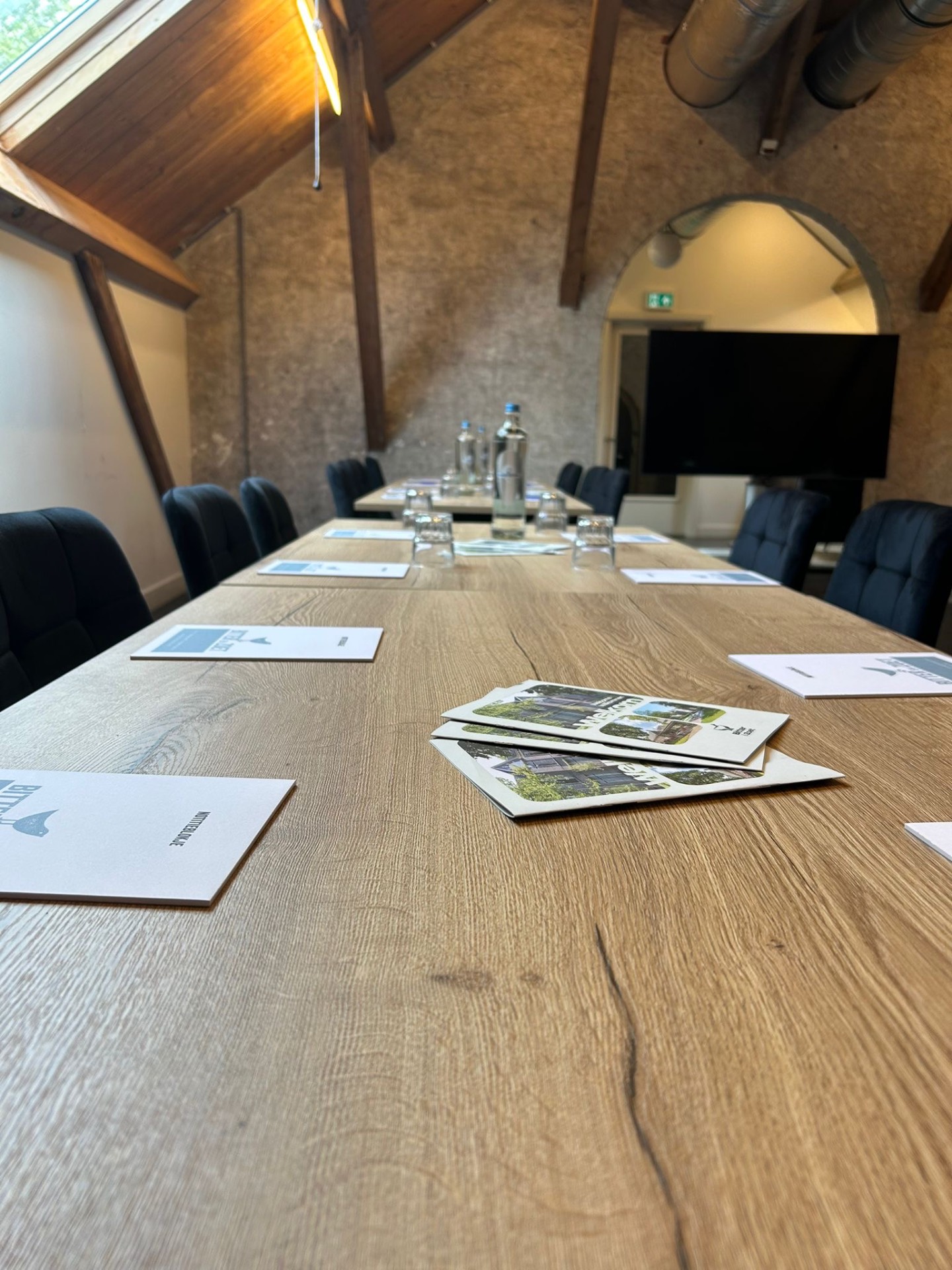 Lange vergadertafel met presentatiescherm op de zolder in Veenhuizen
